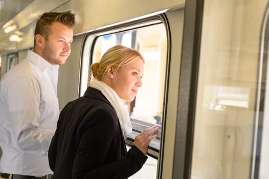 Woman and man looking out train window smiling commuters journey