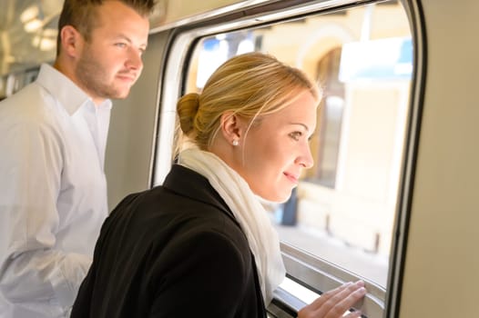 Man and woman looking out train window smiling travel commuters