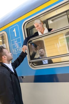 Woman leaving with train man farewell couple smiling travel commuter