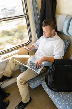 Man texting on phone holding laptop train commuter work journey