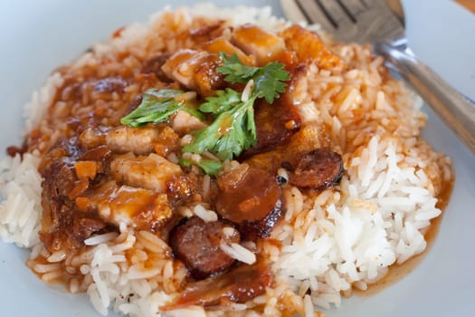 Rick with pork crispy and sausage served with red soup.