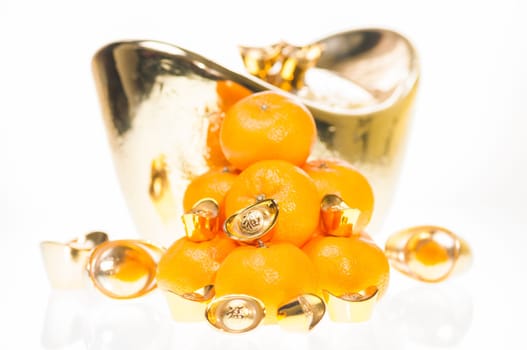 A stack of tangerine with large ingot as background