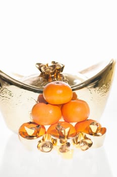 A stack of tangerine with large ingot as background