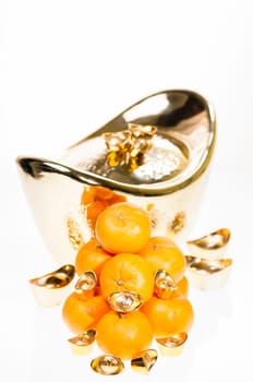 A stack of tangerine with large ingot as background