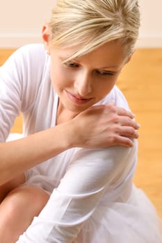 Beautiful ballerina rests sitting on studio floor woman ballet happy