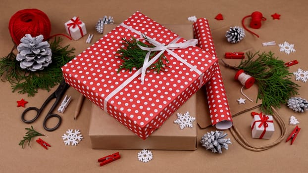 Close up packing and wrapping Christmas gift boxes with red paper, high angle view