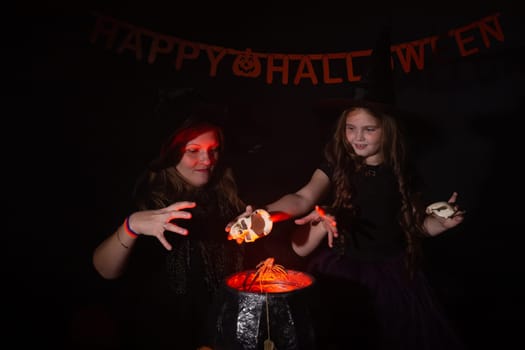 Funny child girl and woman in witches costumes for Halloween with pumpkin Jack and dog