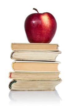 stack of books with apple on top over white background