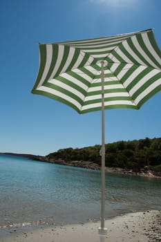 Parasol on the sand beach (Vis, Croatia)