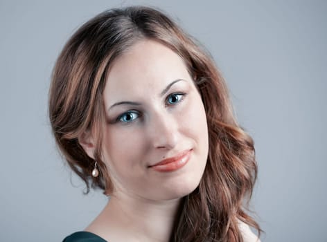 Studio portrait of a beautiful 20 year old woman against gray background.