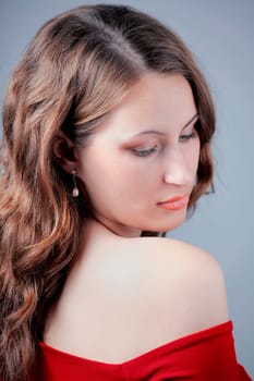 Studio portrait of a beautiful 20 year old redhead woman with red dress.