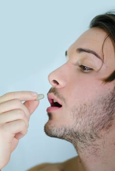 Attractive guy taking prescription drug, medicine or pill