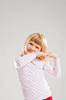 Studio portrait of happy smiling young girl looking forwards with raised hands
