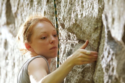 Female rock climber climbing a stone structure