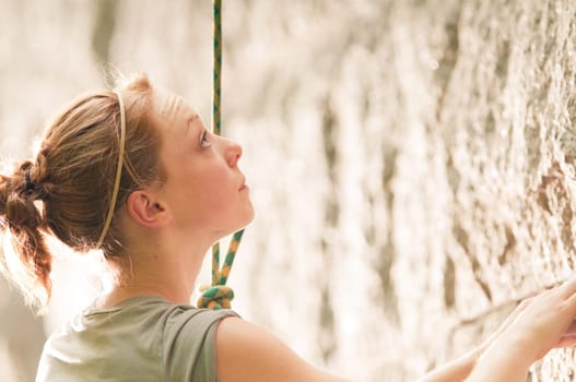 Female rock climber climbing a stone structure