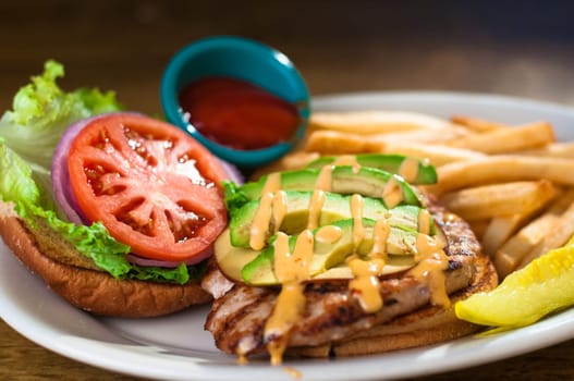 Avocado chicken burger with fries