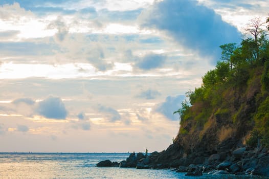 Bali cliffs with silhouetted fisherman looking out to sea