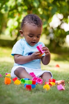 Portrait of a little african american baby boy playing outdoor in the grass