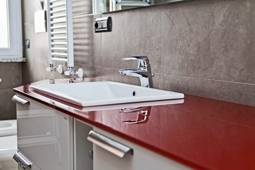 Red bathroom with toilette, bidet, heater, lavabo and mirror