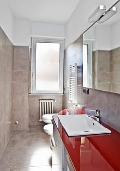 Red bathroom with toilette, bidet, heater, lavabo and mirror in soft hdr