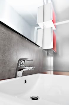Bathroom white porcelain sink closeup with red furniture