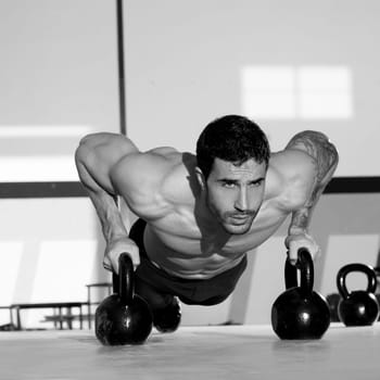 Gym man push-up strength pushup exercise with Kettlebell in a crossfit workout