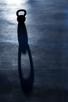 Crossfit Kettlebell weight backlight and shadow on the gym floor