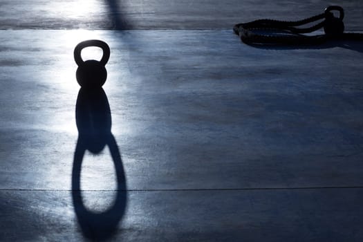 Crossfit Kettlebell weight backlight and shadow on the gym floor