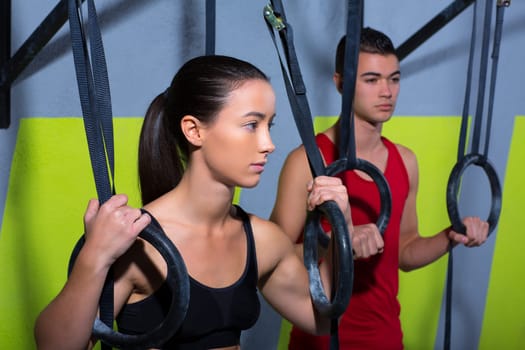 Crossfit dip ring man and woman relaxed after workout at gym dipping exercise