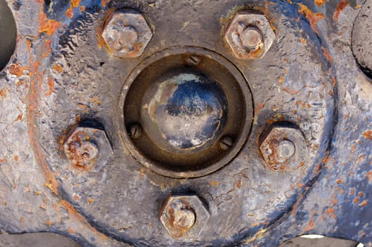 Rusty nuts at the surface of a wheel steel plate- closeup, macro