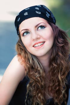 Portrait of a beautiful 20 year old woman outdoor wearing a headscarf like rockers.