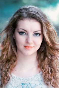 Portrait of a beautiful 20 year old woman looking at camera outdoor in summer.