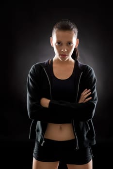 Portrait of sporty young woman on black background