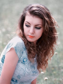 Young woman in her 20s, portrait outdoor, caucasian with long hair looking over shoulder.