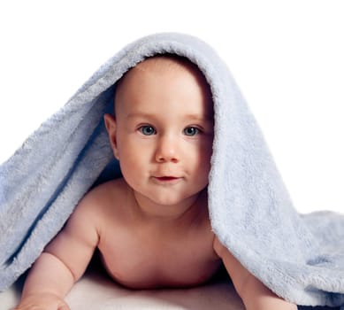 baby looking out from under blue blanket