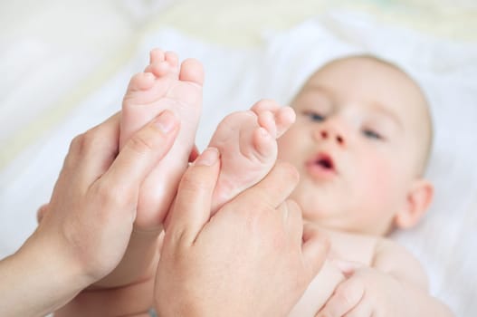 Mother gently massaging her child's feet