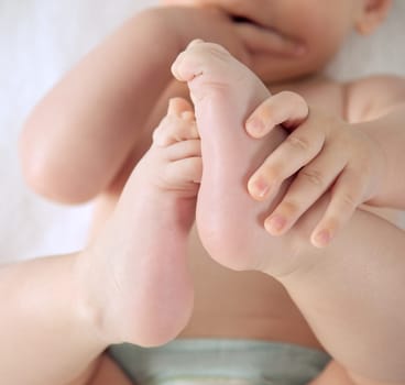 Detail of baby holding his feet