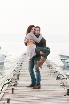 Beautiful relaxed couple on wooden pier in marina