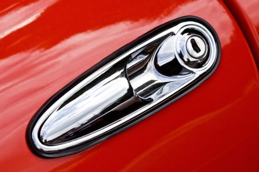 Closeup on door handle of red retro car