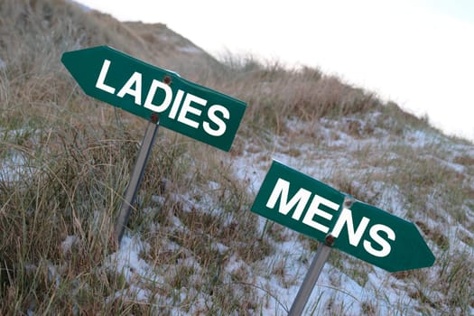 ladies and mens signs on a golf course in winter with ladies on top and mens below