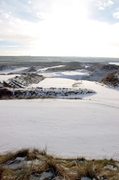 a snow covered with stormy sky links golf course in ireland in winter in black and white