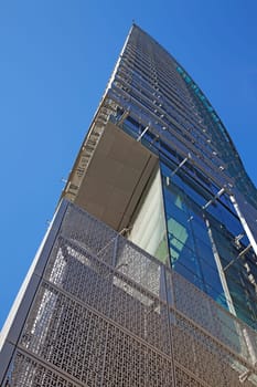 Perspective and underside angle view of modern glass building skyscrapers over blue sky
