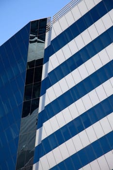 Perspective and underside angle view of modern glass building skyscrapers over blue sky