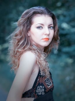 Portrait of a sad 20 year old woman looking at camera over shoulder.