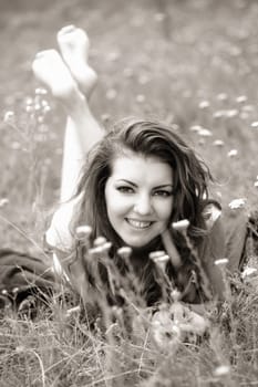20 year old woman lying down on the grass, black and white image.