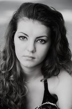 Portrait of a sad 20 year old woman looking at camera, black and white image.