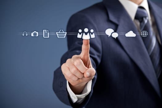 Social media concept - businessman click on virtual icon representing social media. Horizontal composition, blue background, selective focused on hand.