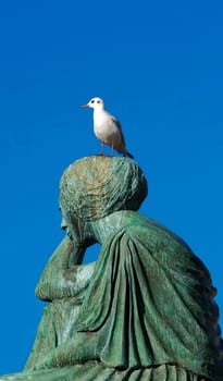 Seated Helvetia with seagull looking back melancholy