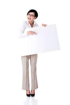 Smiling young business woman showing blank signboard, over white background isolated
