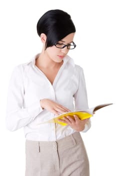 Young focused female reading book, isolated on white
